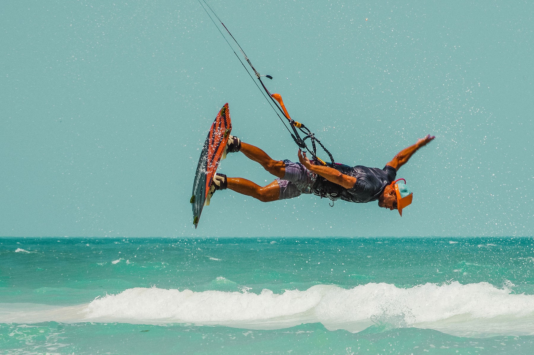 BUOY WEAR founder John Ruffing out in the ocean kiteboarding and wearing an orange floating, waterproof hat.